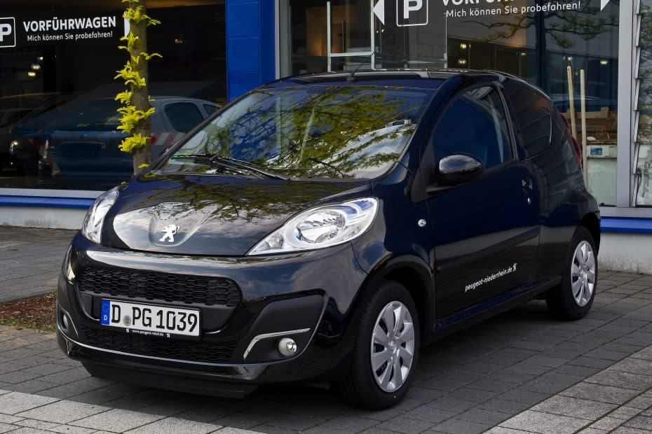 A small black car parked in front of a building.